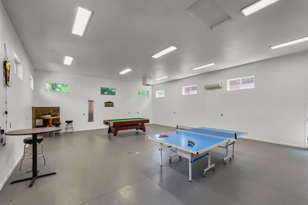 This image captures another angle of the game room, showing a pool table, ping pong table, bar stools, and game-themed decor. The relaxed layout invites guests to move easily between games and socializing, reinforcing the room's role as a favorite gathering spot.