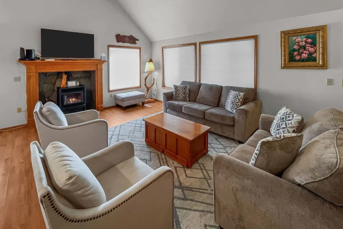 A cozy interior living area with a fireplace, coffee table, and sofas arranged for conversation. The mood is warm and inviting, perfect for relaxing, sharing stories, and group bonding after a day of adventure.